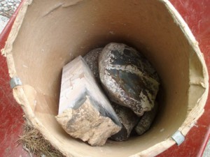 What is in this barrel of rocks that are covered with saw mud?