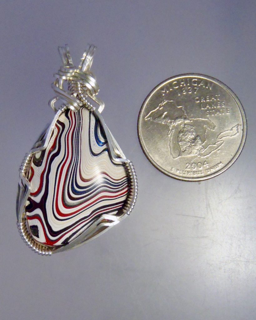 White Fordite Pendant with red blue and black stripes, wire wrapped in silver